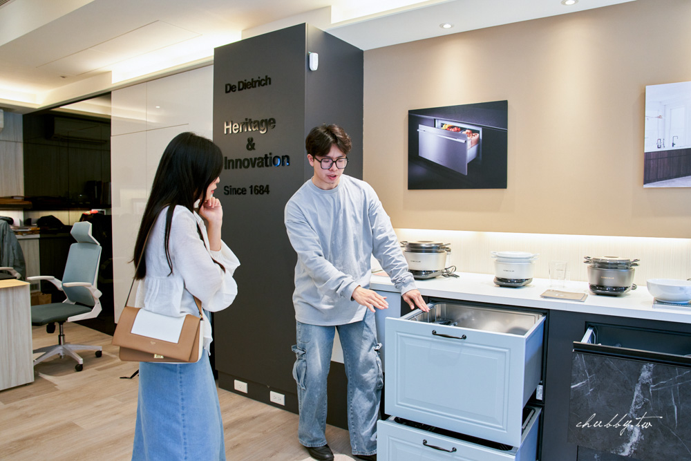 展示間工作人員實際演示如何擺放鍋具與碗盤，抽屜深度明顯充裕
